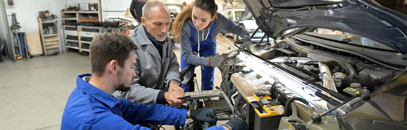 automotive technology teacher and students working on an engine